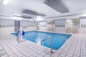 - une grande piscine d'eau bleue dans un bâtiment dans l'établissement Baymont by Wyndham Gurnee, à Gurnee