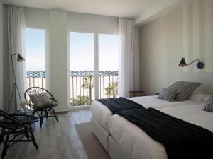 1 dormitorio con 2 camas y vistas al océano en Hotel Boutique Balandret, en Valencia