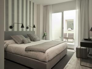 ein Schlafzimmer mit einem großen Bett mit gestreiften Wänden in der Unterkunft Hotel Boutique Balandret in Valencia