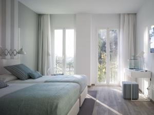1 dormitorio con 2 camas y ventana grande en Hotel Boutique Balandret, en Valencia