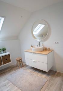 bagno con lavandino e specchio di B&B Hieris't a Hoofdplaat