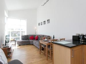 a kitchen and living room with a couch and a table at Pass the Keys 2 Bed Sea View Apartment with Balcony Parking in Benllech