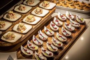 un montón de aperitivos en bandejas sobre una mesa en Hotel Mediterraneo en Roses