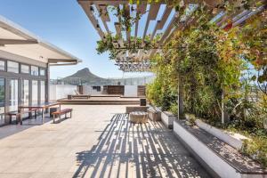 an outdoor patio with a chandelier and plants at Condo at Woodstock Quarters - Stylish 2 ensuite Bedroom Apartment with Spacious Balcony in Cape Town