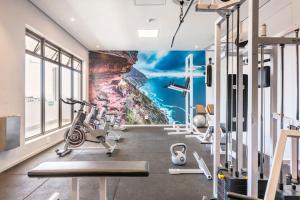 a gym with a wall mural of a cliff at Condo at Woodstock Quarters - Stylish 2 ensuite Bedroom Apartment with Spacious Balcony in Cape Town