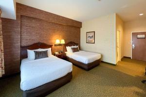 a hotel room with two beds and two lamps at Maine Evergreen Hotel, Ascend Hotel Collection in Augusta