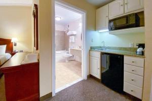 a small kitchen with a sink and a bathroom at Maine Evergreen Hotel, Ascend Hotel Collection in Augusta