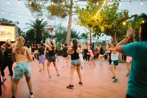 un grupo de personas bailando en una acera en Camping Las Palmeras, en Tarragona