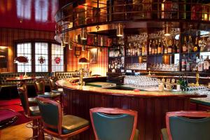 a bar in a restaurant with chairs and a counter at City Hotel in Delmenhorst