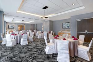 - une salle de banquet avec des tables blanches et des chaises blanches dans l'établissement Hyatt Place Ottawa West, à Ottawa