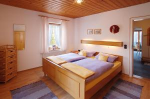 ein Schlafzimmer mit einem großen Bett und einer Holzdecke in der Unterkunft Ferienwohnungen Haus Marienblick in Berchtesgaden