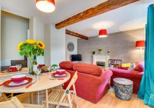 a living room with a red couch and a table at Greyhound Cottage in Kendal