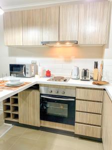 a kitchen with wooden cabinets and a stove top oven at Departamento Pucón in Pucón