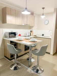 a kitchen with a table and two stools at Departamento Pucón in Pucón