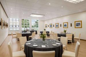 a dining room with tables and chairs in a room at TRYP by Wyndham Montijo Parque Hotel in Montijo