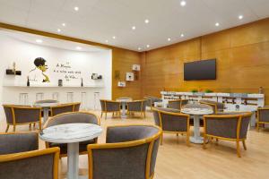 a conference room with tables and chairs and a flat screen tv at TRYP by Wyndham Montijo Parque Hotel in Montijo