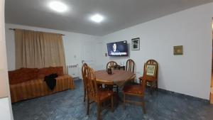 Un comedor con una mesa y sillas y un sofá. en CASA EN JUANA KOSLAY San Luis con pileta, en San Luis