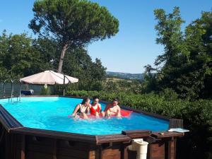 un gruppo di 3 persone in una piscina di Il Giardino dei Pini Affittacamere a Santa Marina