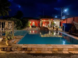 ein Schwimmbad bei Nacht mit Weihnachtsbeleuchtung in der Unterkunft Bed & Breakfast Casa de Valeria in Barra Nova