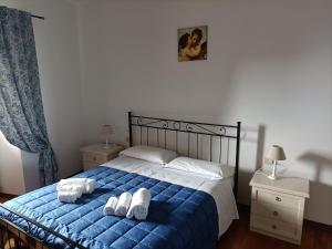 a bedroom with a blue bed with white towels on it at Appartamenti Santa Chiara in Assisi
