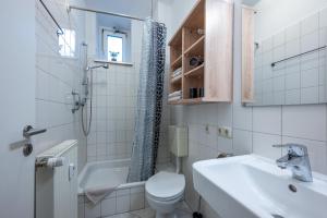 La salle de bains blanche est pourvue de toilettes et d'un lavabo. dans l'établissement Zentral FeWo - EG - Karli - 30qm - Küche - DisneyPlus, à Leipzig