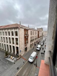 een stadsstraat met auto's geparkeerd voor gebouwen bij Piso Cordon Centro Historico ATUAIRE in Burgos