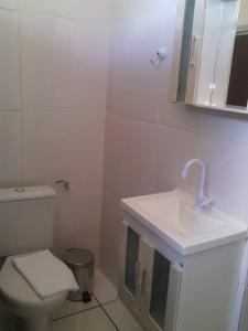 a white bathroom with a toilet and a sink at Lima hospedagem caseira in Olímpia +38 photos