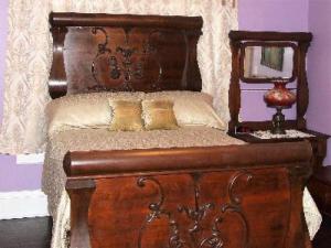 drewniane łóżko z 2 poduszkami i lustrem w obiekcie The Jewell of Vienna w mieście Vienna