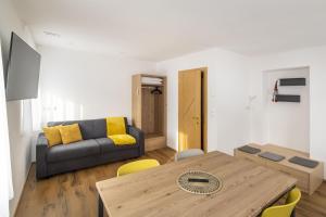 een woonkamer met een tafel en een bank bij Apartments Gasser in Rasun di Sopra