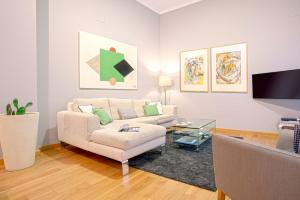 uma sala de estar com um sofá e uma mesa em Genteel Home Vinuesa em Sevilha