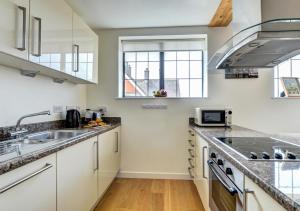 a kitchen with white cabinets and a sink at Flat 8 Broadleys in Swanage