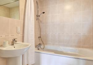 a bathroom with a sink and a tub and a shower at Flat 8 Broadleys in Swanage
