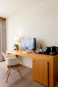 a desk with a computer and a chair on it at Hotel de Milliano in Breskens