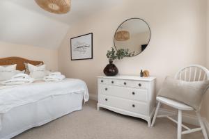 a bedroom with a bed and a mirror and a chair at Stylish Two Bedroom Cottage - In Town Centre in St Ives +32 photos