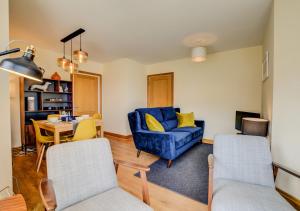 ein Wohnzimmer mit einem blauen Sofa und einem Tisch in der Unterkunft Flat 3 Penlu in Swanage