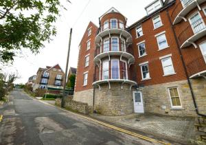 un gran edificio de ladrillo en el lateral de una calle en Flat 3 Penlu, en Swanage