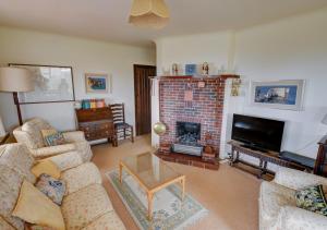 a living room with a couch and a fireplace at Cornerways in Worth Matravers