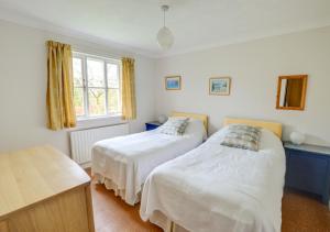 a bedroom with two beds and a window at Wild Hill in Worth Matravers
