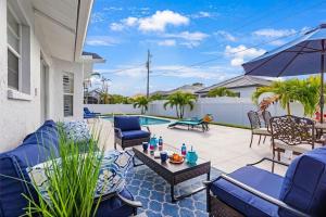 a patio with blue chairs and a table at Private Pool｜Near Beach｜Fenced Yard｜Outdoor Living in Naples