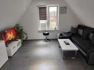 ein Wohnzimmer mit einem Sofa und einem TV in der Unterkunft TRUTH Studio für 3 - Küche - Top Internet - Parkplatz - Modern in Dortmund