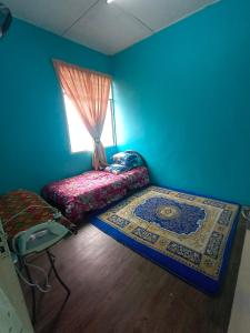 a blue room with a bed and a window at Hazaff Homestay in Sungai Petani