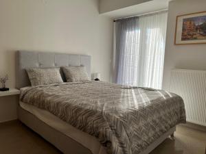 sypialnia z dużym łóżkiem i oknem w obiekcie SilverLine Comfort Apartment w Salonikach