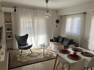 a living room with a couch and a table and chairs at SilverLine Comfort Apartment in Thessaloniki