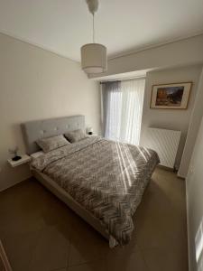 a bedroom with a bed and a window at SilverLine Comfort Apartment in Thessaloniki