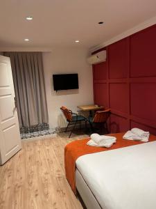 a hotel room with two beds and a table and a tv at St Moscow Suites Taksim in Istanbul