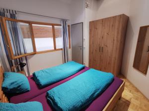 Habitación pequeña con 2 camas y ventana en Apartment Bergführer, en Warth am Arlberg