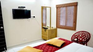 una camera da letto con un letto e una televisione a parete di Hotel AK Tirupati a Tirupati
