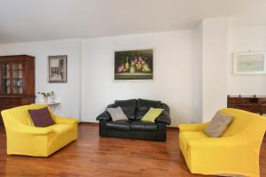 2 sillas amarillas y un sofá negro en la sala de estar en Florence Apartment-Hosted by Sweetstay, en Florencia