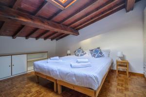 1 cama blanca grande en una habitación con techos de madera. en Florence Apartment-Hosted by Sweetstay, en Florencia