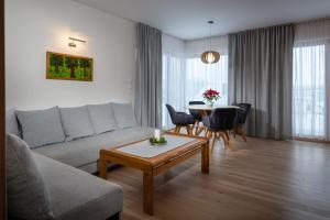 - un salon avec un canapé et une table dans l'établissement TATRYSTAY Hillside Apartments, à Dolný Kubín